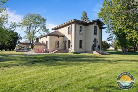 Step outside into your own private grounds, red chairs waiting on the patio, garden beds to explore, and the pavilion just steps away across four and a half acres that are entirely yours.
