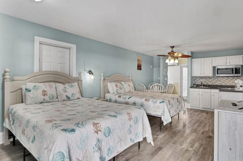 Spacious sleeping area with two comfortable queen beds, coastal décor, and plenty of room for couples or small families to unwind after a beach day 