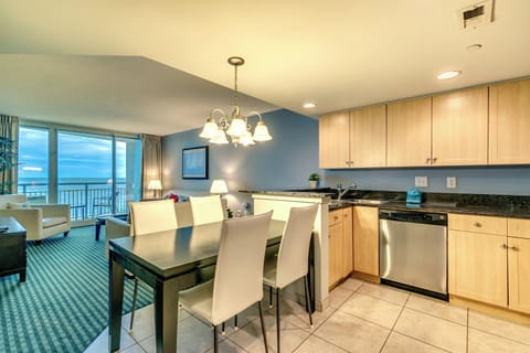 Modern dining and kitchen area with elegant flooring, sleek furniture,