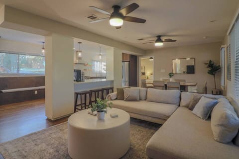 Spacious open-concept living area with a large West Elm sectional, oversized coffee table perfect for board games, and a 75” smart TV for streaming. Flows seamlessly into the kitchen and dining space for easy group gatherings.