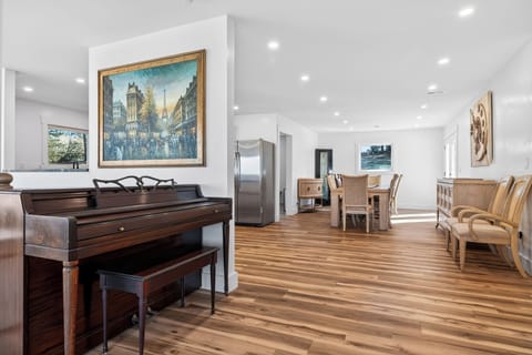 Music-meets-mountain vibes—upright piano in the open-concept living space with forest views.