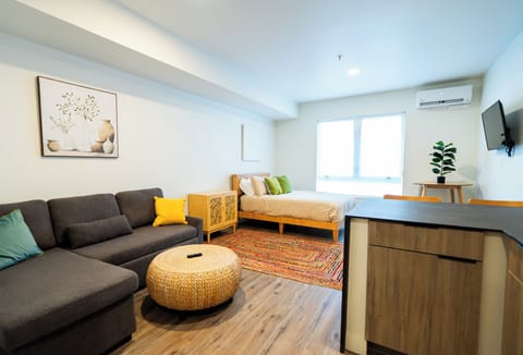 Your stylish studio combines comfort with function—relax on the plush sofa, work at the sleek desk, or unwind in your cozy sleeping area with city views.