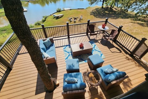 Lower deck seating area with cozy patio furniture and kayaks for guest use.