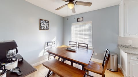 The dining area includes a large dining table and a coffee bar