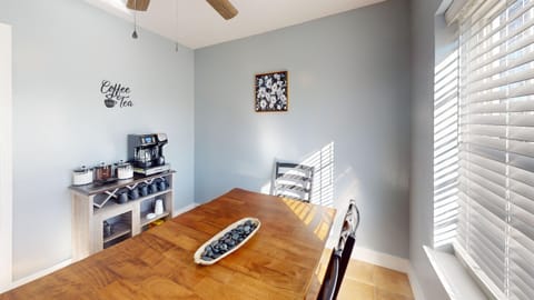 The dining area includes a large dining table and a coffee bar