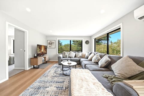 Bright living room with natural light and leafy outlook.