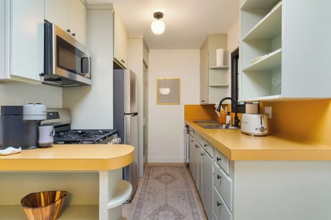 Modern kitchen with stocked coffee bar—Nespresso, drip & kettle.