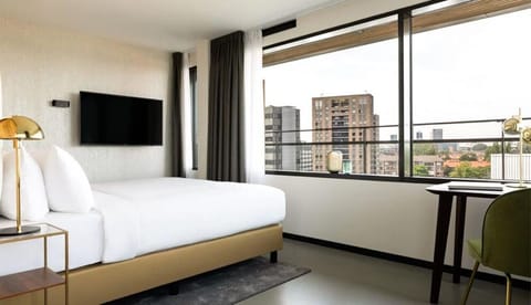 Recharge in crisp linens while the city skyline fills the window.
