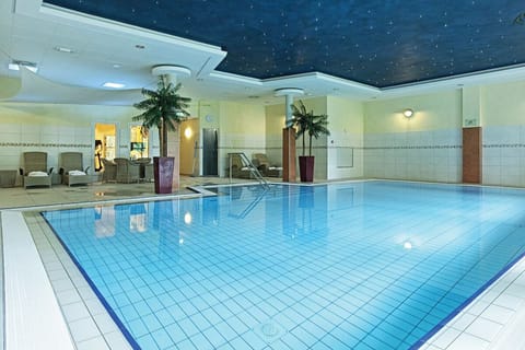 Unwind poolside with loungers, warm air, and calm water.