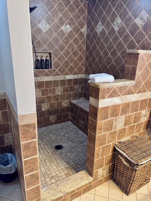 Walk-in tile shower with bench seating and built-in niche