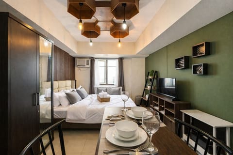 Comfortable city studio with hotel-style bedding, dining table, entertainment area, and a thoughtfully designed layout.