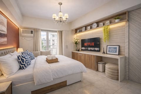 Sun-filled, modern bedroom with a plush queen bed, streaming-ready Smart TV (Netflix), high-speed WiFi, AC, and a dedicated workspace — the perfect cozy home base for relaxing after a day out.