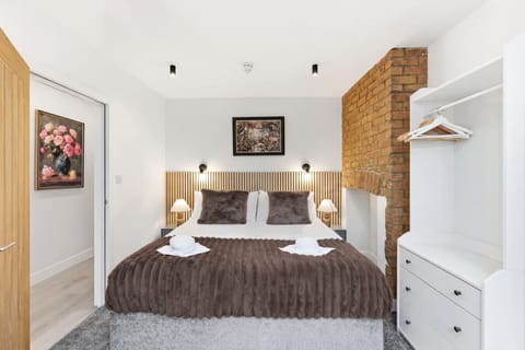 Bedroom One features a private patio, Smart TV, and a zip-and-link bed. The bed is configured as twin beds by default but can be converted into a king-size bed upon request.