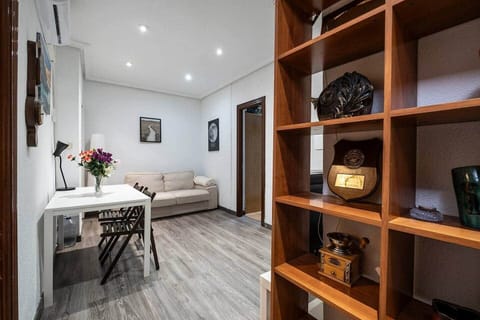 Salón con sofá, mesa plegable y estantería de madera
