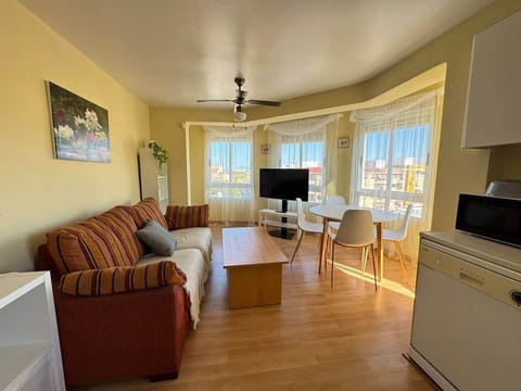 Salón comedor con sofá, TV y galería acristalada