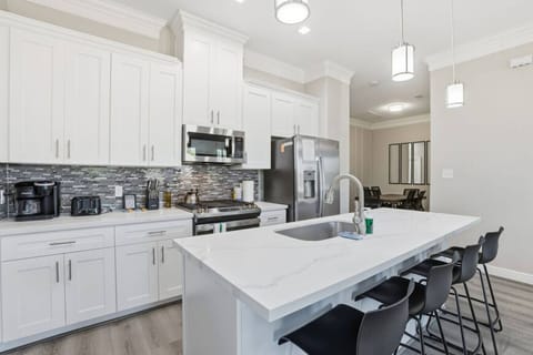 Contemporary cooking space featuring a large prep surface, sleek finishes, and stool seating—great for meals, conversation, and shared moments.