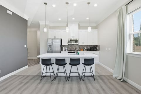Bright, modern kitchen with oversized island, bar seating, and sleek finishes—perfect for cooking, dining, or gathering with friends.