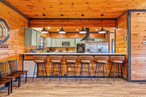 The modern kitchen has a bar, 2 refrigerators, 2 sinks, 2 dishwashers, 2 ovens, and an electric cooktop.