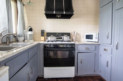 Modern kitchen with stainless steel appliances – Fully equipped for all your cooking needs with sleek gray cabinetry and gas stove.