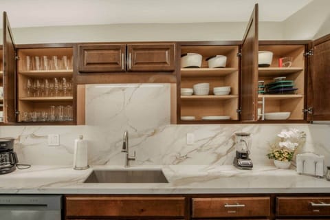 Kitchen is stocked with dishes, cups, glasses, wine glasses, bowls, pyrex storage containers, coffee mugs