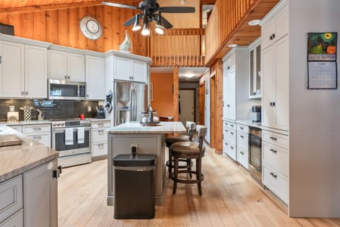 Modern kitchen with stainless steel appliances, island seating, and wood accents — perfect for cooking and entertaining
