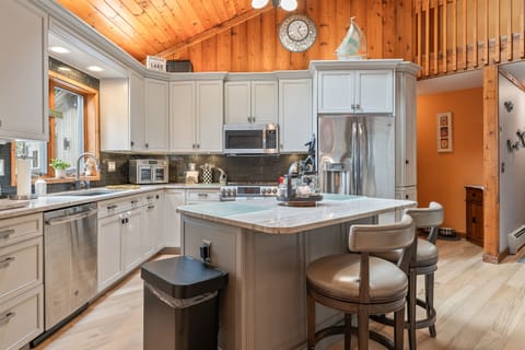 Bright, fully stocked kitchen with breakfast bar and modern finishes — the heart of your lakehouse stay