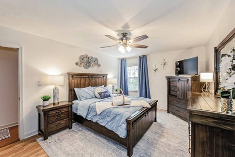 The Bluebell Room offers a queen bed, two dressers including a vanity, and a flat‑screen Amazon TV. Two windows with blackout and noise‑reducing curtains add serenity. Ensuite bathroom and walk‑in closet complete this private, comfortable escape.