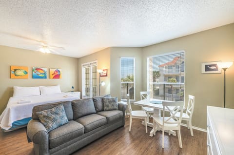 Relax in your bright, open-concept studio with comfortable seating, dining space, and cheerful coastal artwork creating a welcoming retreat.