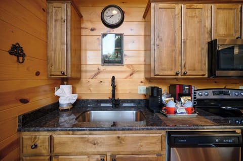 Your cozy cabin kitchen features warm wood cabinets, granite counters, and everything you need for mountain cooking adventures.