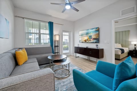 Unwind in your stylish living space with plush seating, modern entertainment center, and vibrant turquoise accents creating the perfect atmosphere for relaxation.