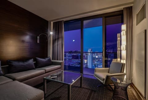 Relax and unwind in the cozy living area with plush seating, smart TV, and stunning city views.