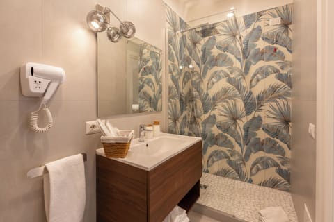 Deluxe Quadruple Room | Bathroom | Shower, hair dryer, slippers, towels