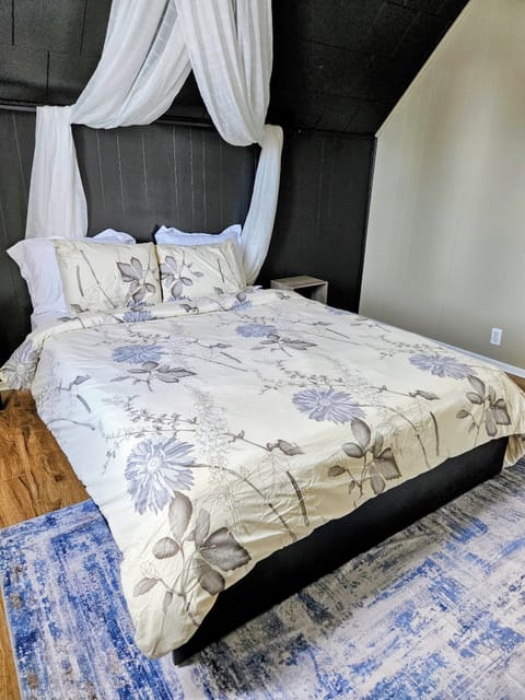 Bright and cozy bedroom with a comfortable queen bed, soft lighting.