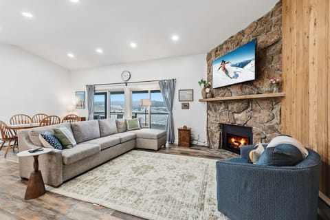 Cozy up by the crackling stone fireplace while mountain views fill your windows in this stylish alpine retreat.