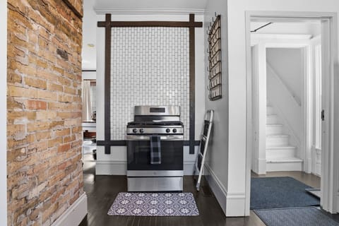 Cook your favorite meals on this stylish gas range, surrounded by charming exposed brick and modern tile backsplash.