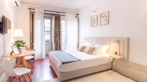 Bright and airy bedroom with access to a patio. #PortoStay #NaturalLight