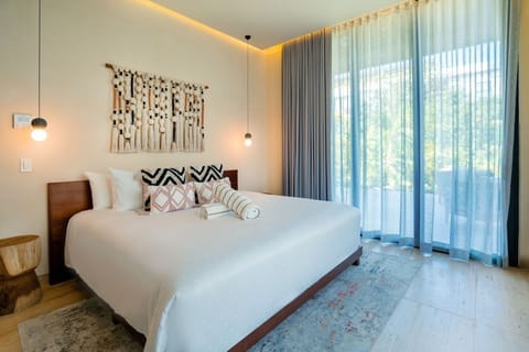Sink into a cloud-soft bed beside sunlit, leafy views.