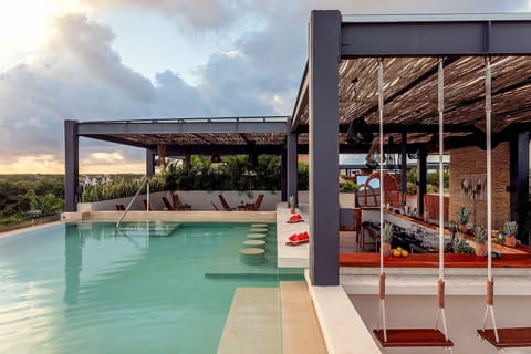 Sip cocktails poolside while the horizon glows at dusk.