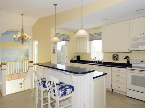 The well-appointed kitchen features stylish blue countertops and ample cabinet space, perfectly complemented by a cheerful island for casual dining.