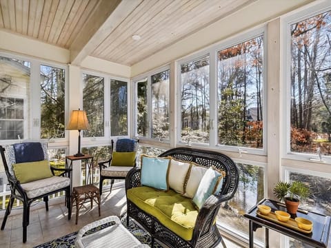 Savor morning coffee or evening breezes in the airy four-season sunroom, filled with natural light and cozy seating.