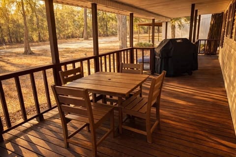 Enjoy meals outdoors on the covered deck with a dining table and seating for four. Fire up the grill for an easy cookout, then linger and take in the peaceful, wooded surroundings.