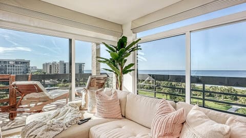 Sunlit living room with panoramic city and ocean views