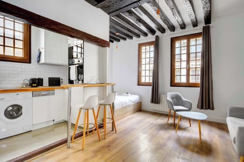 Studio lumineux avec coin cuisine avec bar, coin nuit et espace détente.