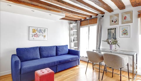 Espace lumineux et chaleureux avec canapé convertible en lit et coin repas.