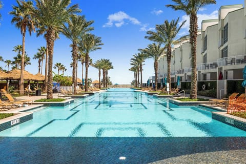 Stunning resort pool with palm trees and ocean breezes, your daily paradise.