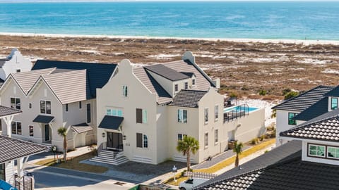 Coastal community featuring modern homes with beach access and stunning turquoise waters just beyond the dunes.