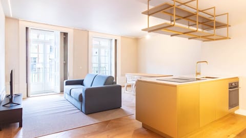 A bright open-plan space where modern comfort meets bold design, centered around a striking golden kitchen island.

#ModernLiving #CityStay #DesignApartment #PortugalHomes