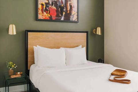 Queen bedroom with natural light and hotel quality linens