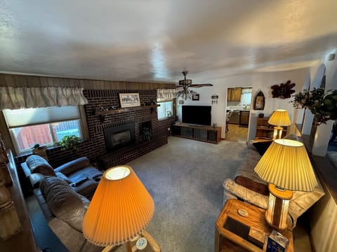 Family room with couch, recliners, fireplace and TV