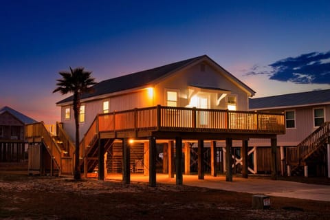 This beachfront beauty lights up at sunset with its elevated deck and direct sand access—pure coastal living.
